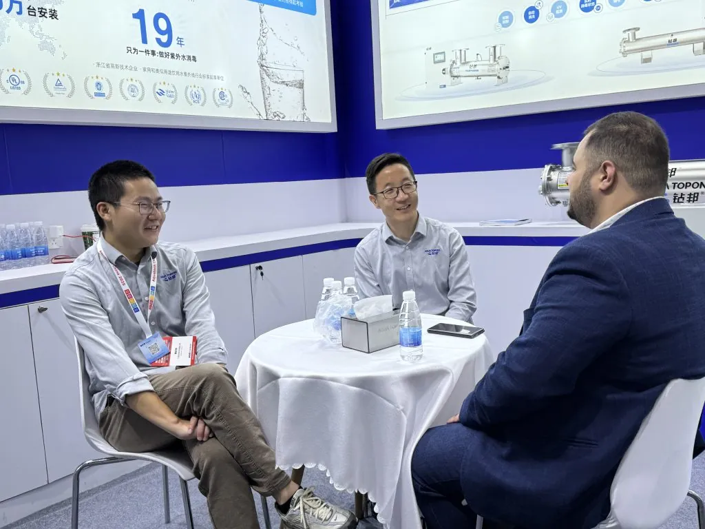 Tom Cai and Jason Ma engaging in insightful discussions with industry peers about the latest trends in the water sector.